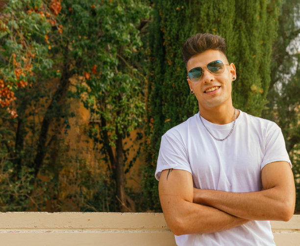 一个戴着太阳镜，双臂交叉微笑的人图片下载