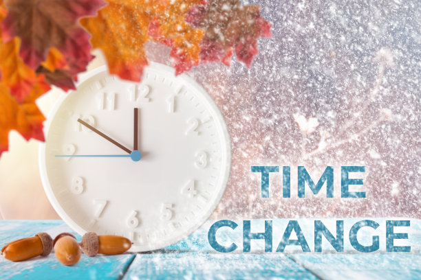 时间的概念是变化的。钟表和树叶放在木桌上，上面还有橡子图片下载