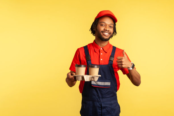 快递员拿着咖啡，用一次性杯子提供饮料，竖起大拇指，诸如此类的手势。图片下载