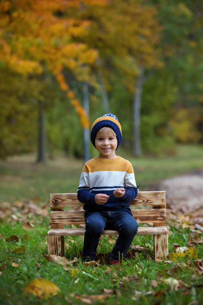 快乐的孩子，在秋天的公园里摆着五彩缤纷的造型，玩耍着图片下载