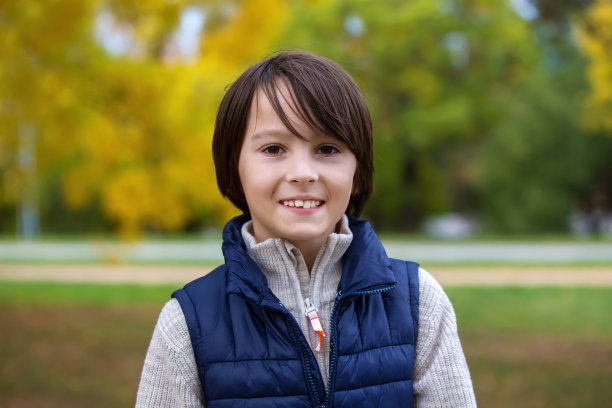 快乐的孩子，在秋天的公园里摆着五彩缤纷的造型，玩耍着图片下载