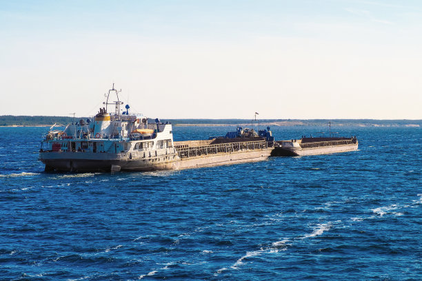 在夏天的河流上推着一艘重型驳船的拖船推手图片下载