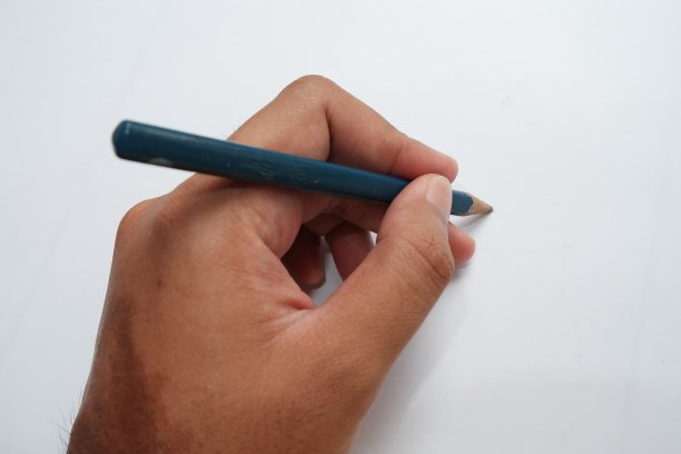 一个亚洲人的手拿着一支铅笔图片下载