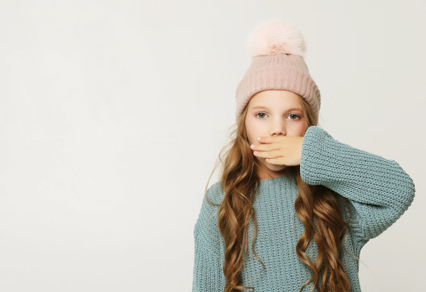 小女孩用手捂着嘴。生活方式和童年概念图片下载