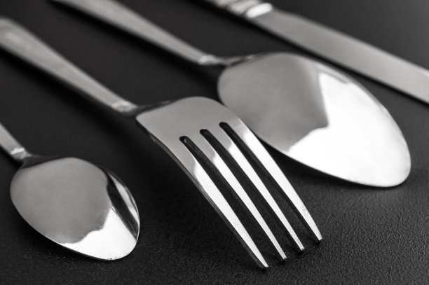 叉子、刀和勺子放在黑色背景上。关闭了。图片下载