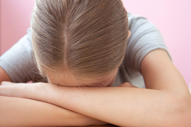 疲惫的学生在明亮的粉红色背景下准备考试图片下载