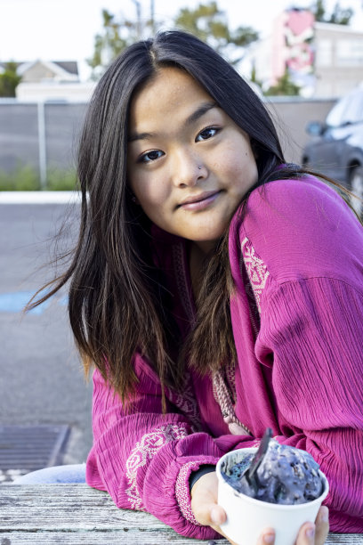 年轻女子在外面吃着一碗冰淇淋放松图片下载