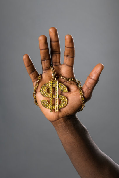 一个黑人举着项链上的金元符号图片下载