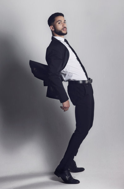 摄影棚里一个年轻人在灰色背景下摆姿势图片下载