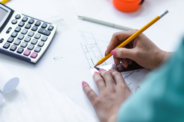 女工程师手拿黄色铅笔的特写照片。图片下载