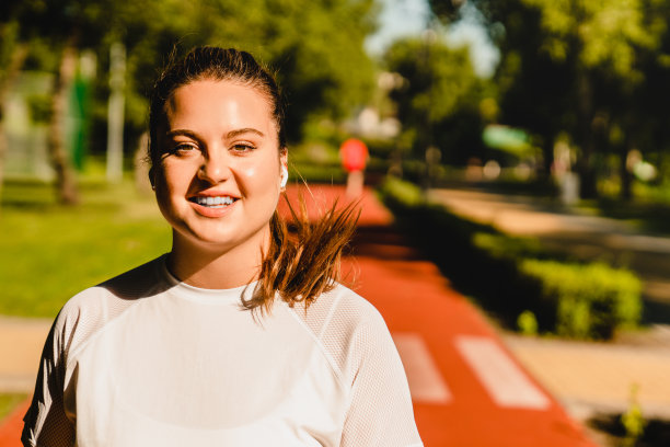 微笑适合大尺码肥胖的运动员运动的女人跑步慢跑减肥燃烧卡路里在户外体育馆早上图片下载