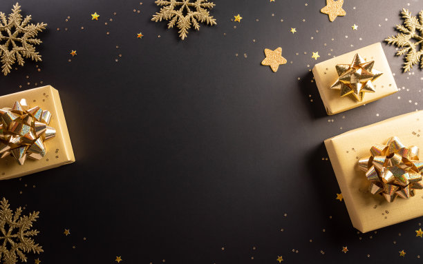 黑色星期五圣诞节礼品盒和黑色背景上的金色雪花的顶部视图。购物概念节礼日和黑色星期五构成。图片下载