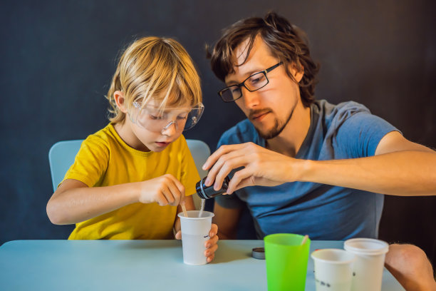 父亲和儿子在家里进行化学实验。家里做的粘液图片下载