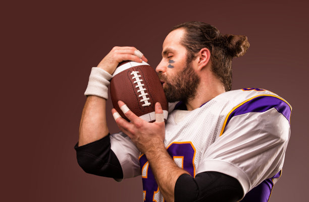美国橄榄球运动员的特写，他轻轻地吻着球图片下载