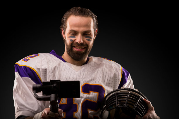 身穿白色制服的足球运动员在黑色背景下自拍图片下载