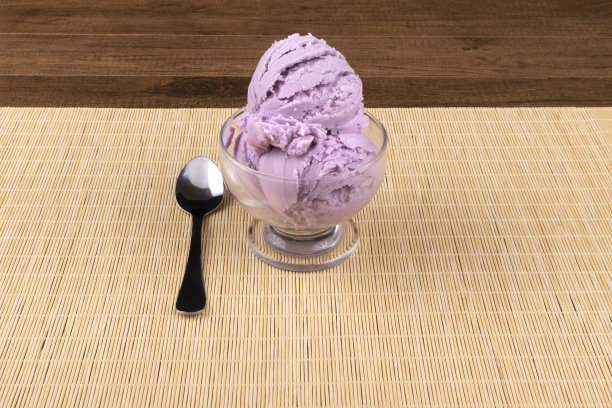 美味的紫色葡萄口味的冰淇淋玻璃碗和三个冰淇淋球。用勺子舀到左边。将元素居中，留出文本空间图片下载