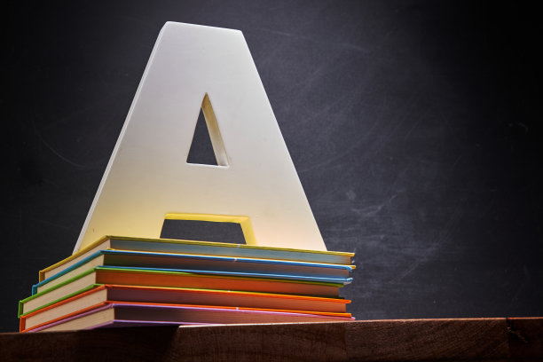 在靠黑板的一堆书上写着大写字母A图片下载