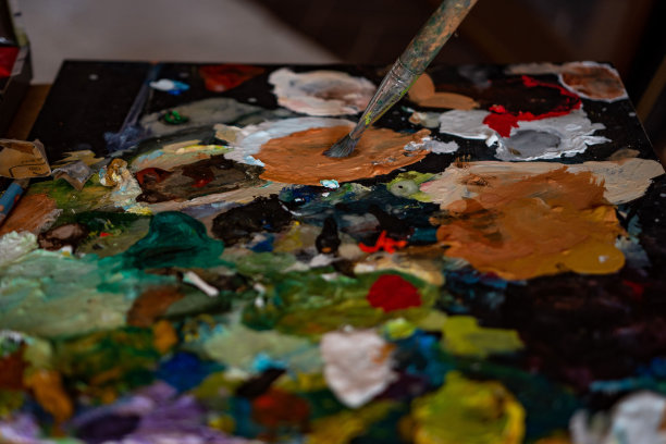 男艺术家用画笔蘸颜色作画图片下载