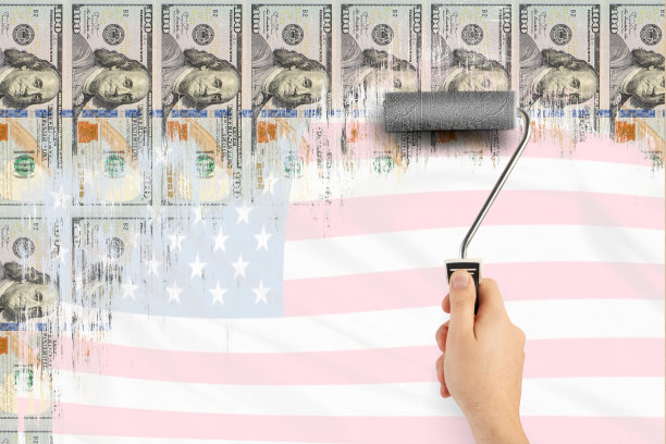 印钞。美元印刷机。经济激励措施。通货膨胀和经济危机。一个男人的手用滚筒画美元来刷墙。股市泡沫概念图片下载