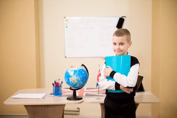 一个男孩在教室里看着相机。图片下载