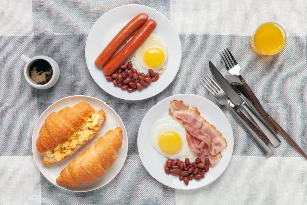 丰盛的家庭自制早餐。桌子上有鸡蛋、熏肉、香肠、豆子、羊角面包、吐司和咖啡。俯视图图片下载