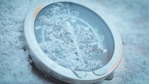 银色金属的户外厨房烤架热温度计在冬天的早晨被雪花覆盖图片下载