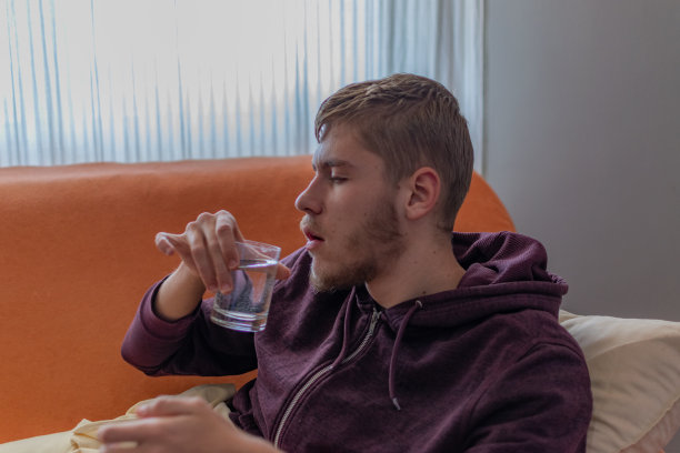 生病的年轻人在家休息喝茶看电视图片下载