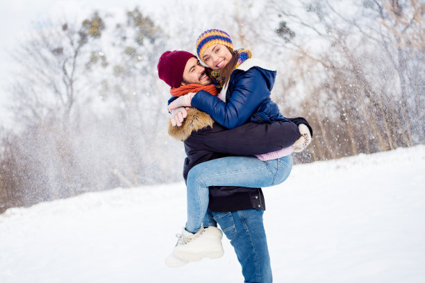 开朗的帅哥抱着相当积极的女孩拥抱的照片，在森林户外有好心情，闲暇时间图片下载