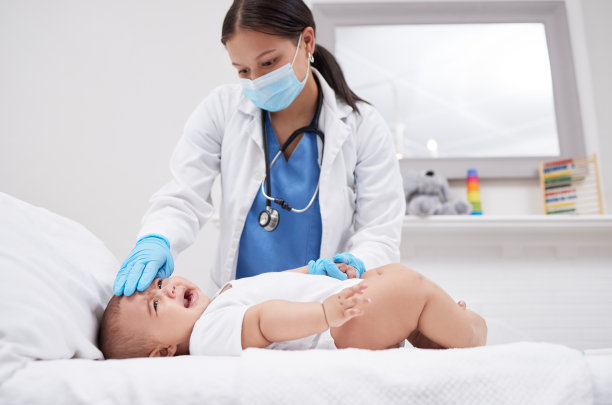 医生在医院里给婴儿测体温的照片图片下载