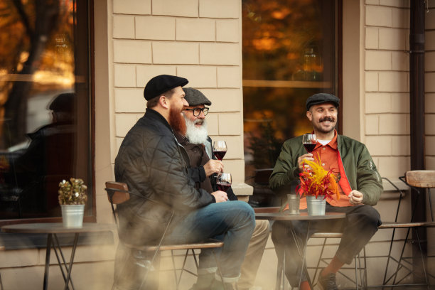 温暖的秋日，朋友们在咖啡馆聚会。喝红酒图片下载