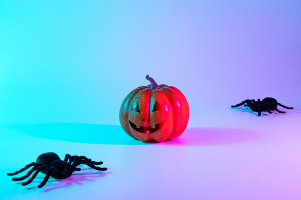 万圣节快乐。黑色的夜蜘蛛，可怕的幽灵南瓜在夜晚霓虹灯万圣节背景。万圣节快乐的概念。框架。副本的空间。图片下载