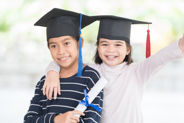 快乐的亚洲女学生毕业戴着毕业帽，手持卷证书庆祝毕业。毕业典礼概念照片图片下载