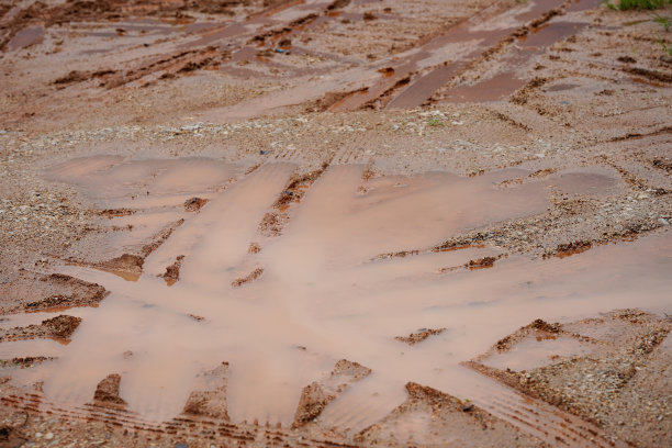 泥泞的泥土和汽车车轮的痕迹。图片下载