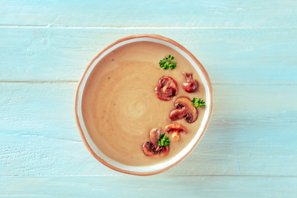 配以欧芹的蘑菇汤，以木制背景从上方拍摄图片下载