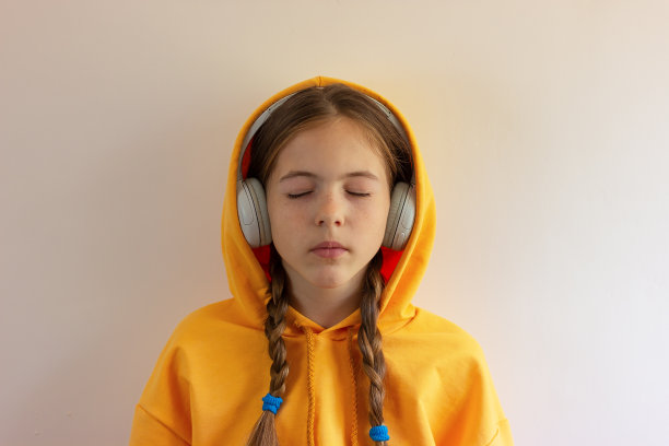 一个女孩闭着眼睛戴着耳机听音乐图片下载