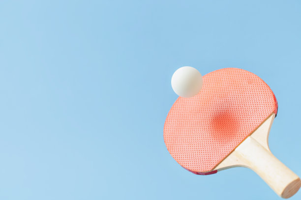 红色乒乓球，乒乓球球拍和蓝色背景上的球。夏季运动活动概念。飞行图片下载