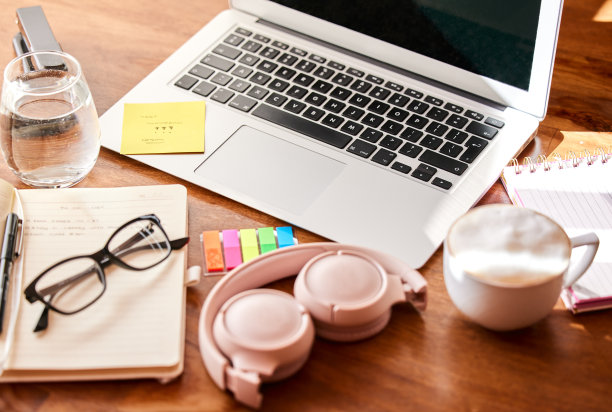 一间空办公室，桌上放着一台笔记本电脑和一套耳机图片下载