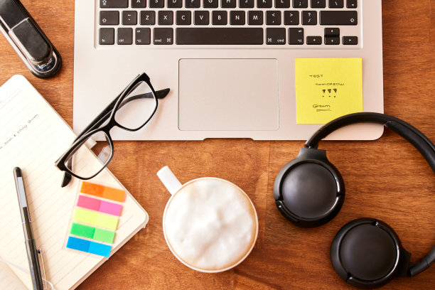 一间空办公室，桌上放着一台笔记本电脑和一套耳机图片下载