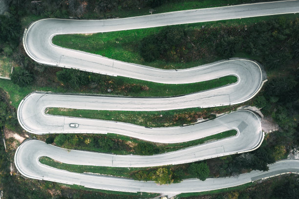 在瑞士阿尔卑斯山圣贝纳迪诺山口蜿蜒道路上的无人机视图图片下载