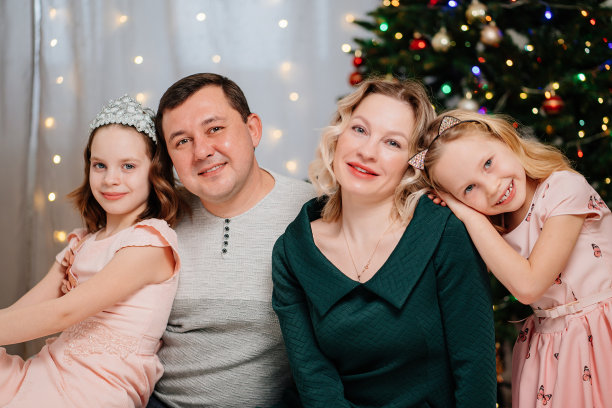 圣诞树前一个欢乐美丽的家庭。图片下载