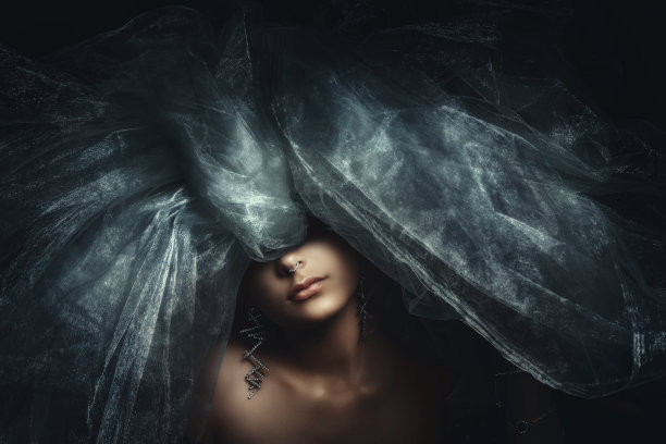 一幅美丽的女模特的肖像，她戴着一个大大的薄纱头饰，遮住了她的眼睛图片下载