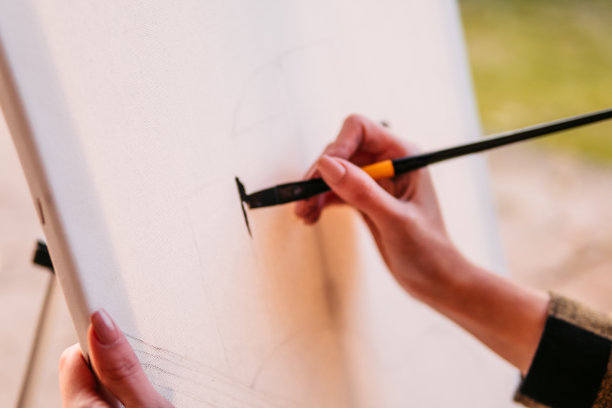 一位年轻女艺术家在帆布上作画的手图片下载