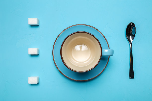杯子与碟子，勺子和方糖在蓝色背景，从顶部的观点与地方为您的文本。概念上的食物照片。静物。图片下载