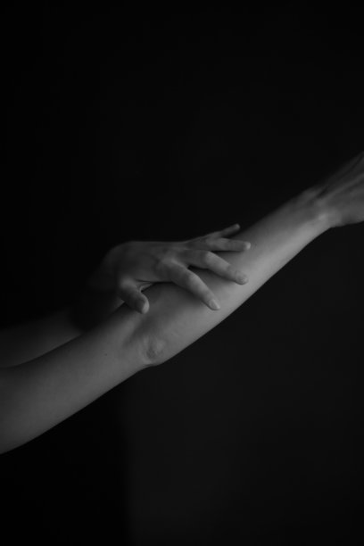 身体细节，女性手掌在黑暗的背景，一个美丽的模糊和不聚焦的手和手指的图像图片下载