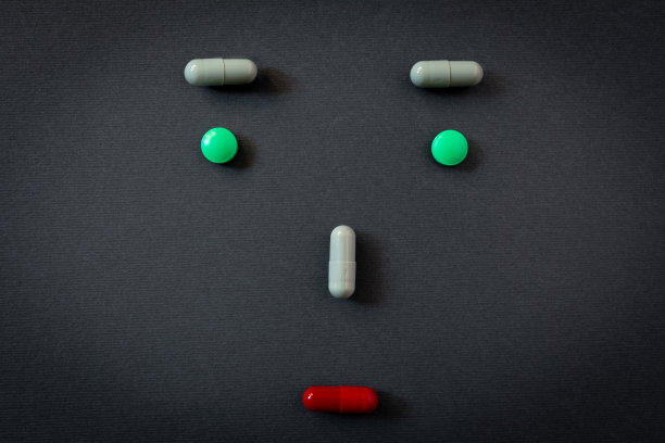 创意emoticon，悲伤的脸的人与不同的药片和药丸的药物在黑色的背景图片下载