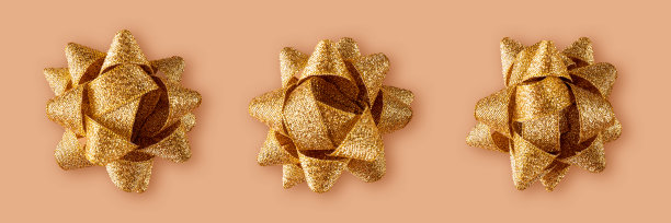 米色背景上的节日金色礼品丝带。网站横横幅图片下载