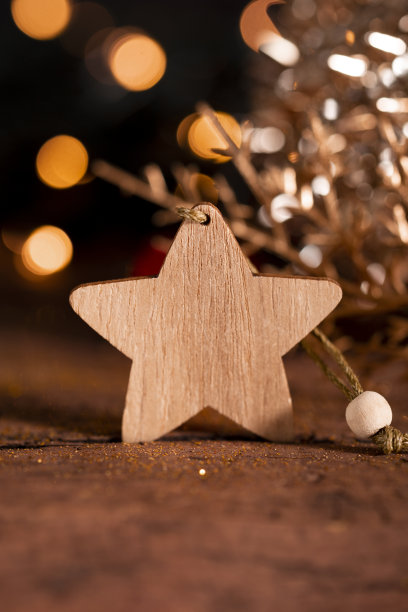 新年贺卡与自由空间的文字。木制星星和圣诞装饰在一个黑暗的背景与美丽的散景垂直照片图片下载