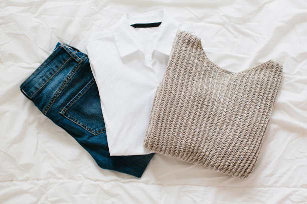 时尚的女性服装和配饰。平躺，女性休闲装:白色衬衫，蓝色牛仔裤和毛衣。图片下载