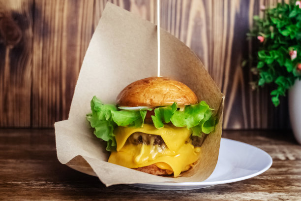 一个双层汉堡的特写镜头。餐馆或咖啡馆里的成人快餐。微距照片的汉堡原料与肉，奶酪和香草。为全家准备的环保汉堡图片下载