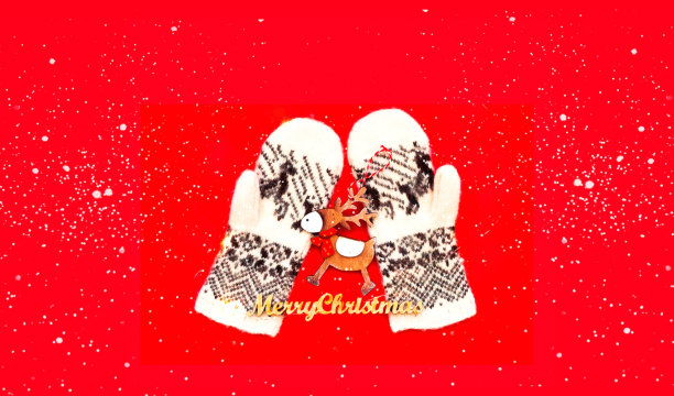 针织手套与斯堪的纳维亚图案和木制鹿在红色背景。圣诞贺卡与你的文字的地方。图片下载